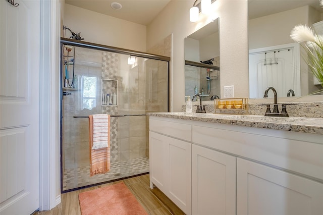 bathroom featuring vanity, a shower with door, and hardwood / wood-style flooring