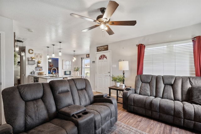 living room featuring wood-type flooring, sink, and ceiling fan