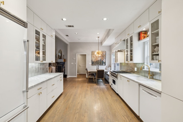 kitchen with sink, white cabinets, and high quality appliances