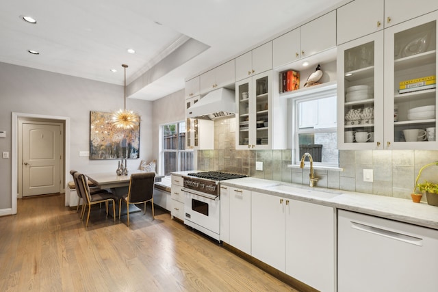 kitchen with sink, white appliances, white cabinetry, custom range hood, and light stone counters