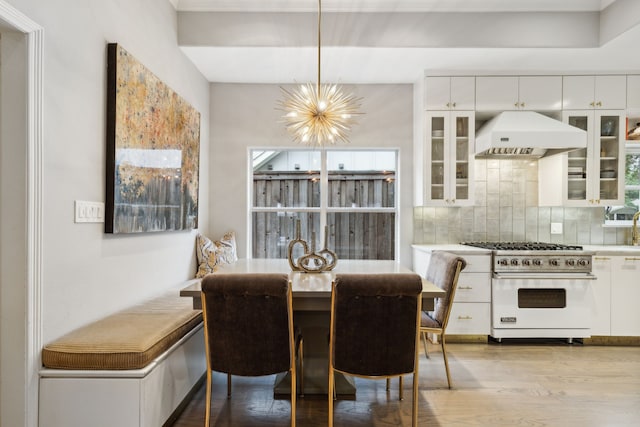 dining space with light hardwood / wood-style floors and a chandelier