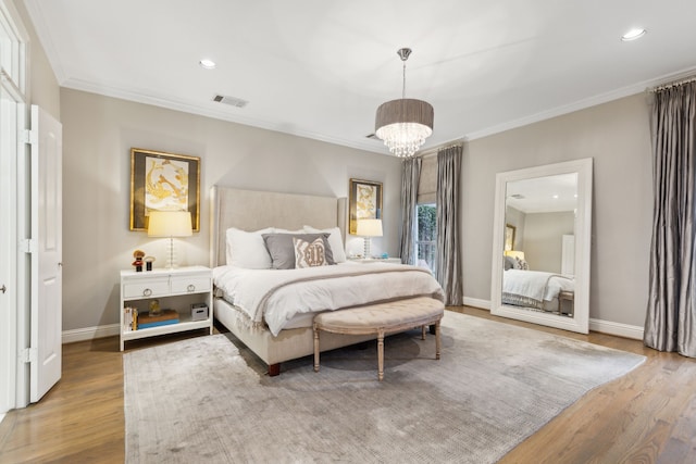 bedroom with an inviting chandelier, ornamental molding, and hardwood / wood-style floors