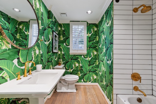 full bathroom with hardwood / wood-style floors, toilet, crown molding, and bathing tub / shower combination