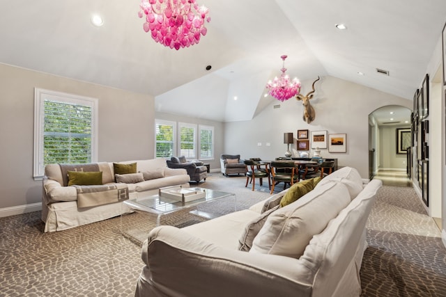 living room featuring carpet flooring, lofted ceiling, and an inviting chandelier