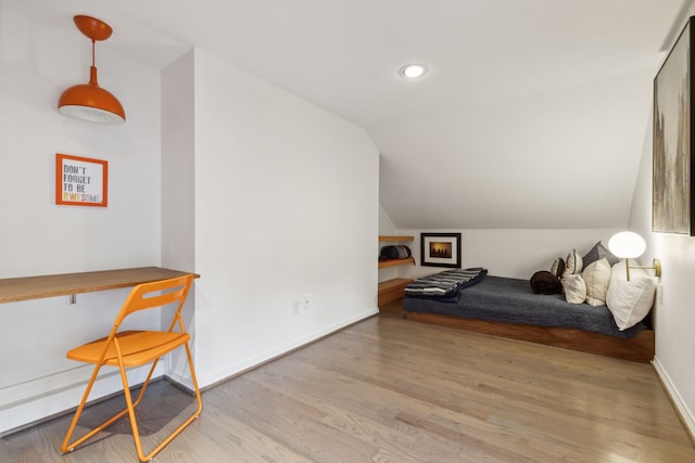 additional living space featuring light wood-type flooring and vaulted ceiling