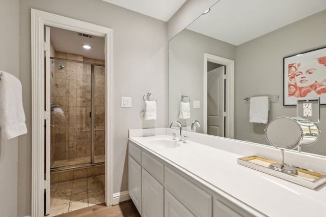 bathroom with wood-type flooring, walk in shower, and vanity