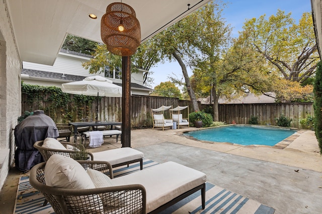 view of pool with grilling area and a patio area