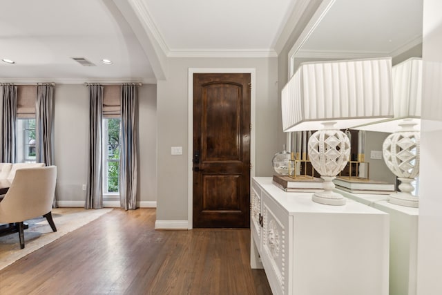 foyer entrance featuring dark wood-type flooring and ornamental molding