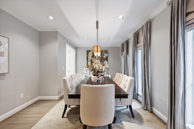 dining area featuring light wood-type flooring, crown molding, and a chandelier