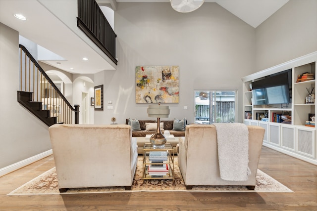 living room featuring high vaulted ceiling and hardwood / wood-style flooring