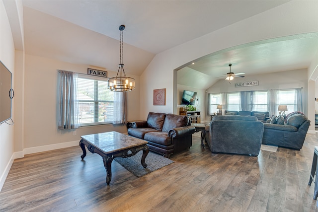 living room featuring lofted ceiling, hardwood / wood-style floors, and ceiling fan with notable chandelier