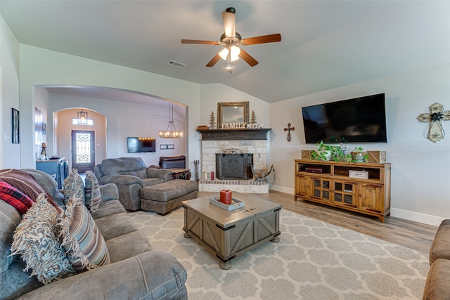 living room with hardwood / wood-style flooring, lofted ceiling, and ceiling fan with notable chandelier