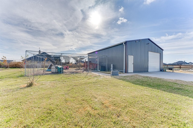 view of outdoor structure featuring a garage and a lawn