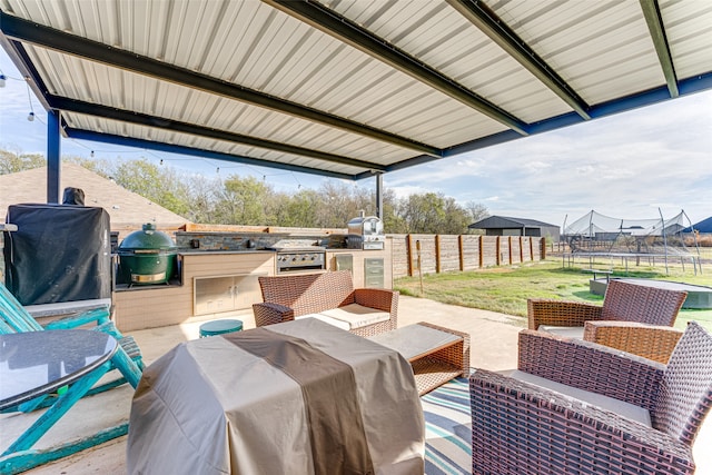 view of patio featuring an outdoor kitchen, area for grilling, and a trampoline