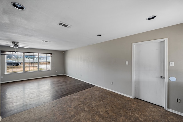 spare room featuring ceiling fan and dark wood-type flooring