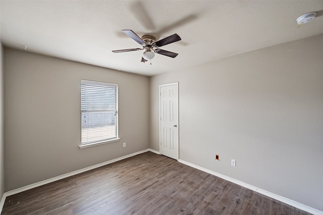 spare room with ceiling fan and dark wood-type flooring