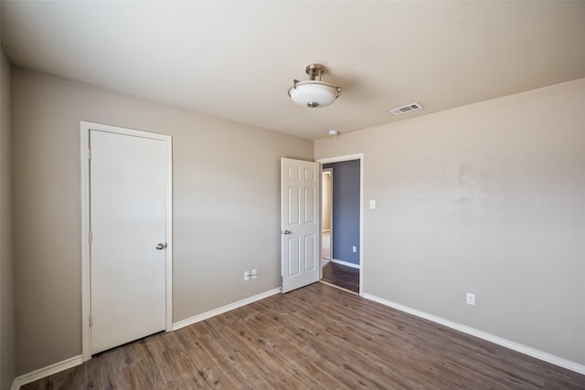 unfurnished bedroom with dark wood-type flooring