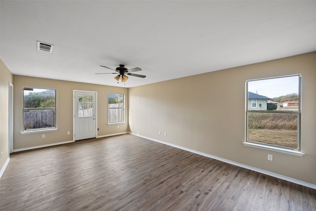 empty room with ceiling fan and dark hardwood / wood-style flooring