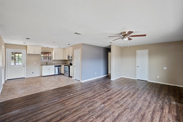 unfurnished living room with ceiling fan, dark hardwood / wood-style flooring, and sink