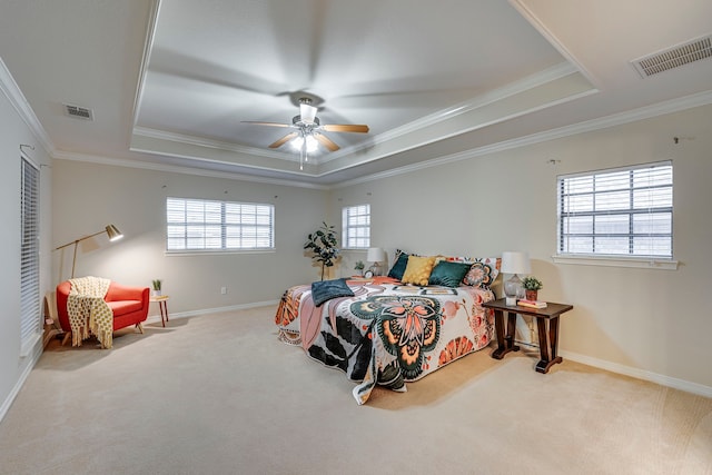 bedroom with a tray ceiling, ceiling fan, carpet, and ornamental molding