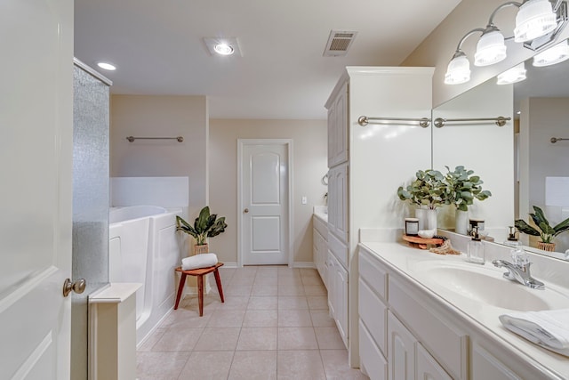 bathroom featuring tile patterned flooring, vanity, and a bath