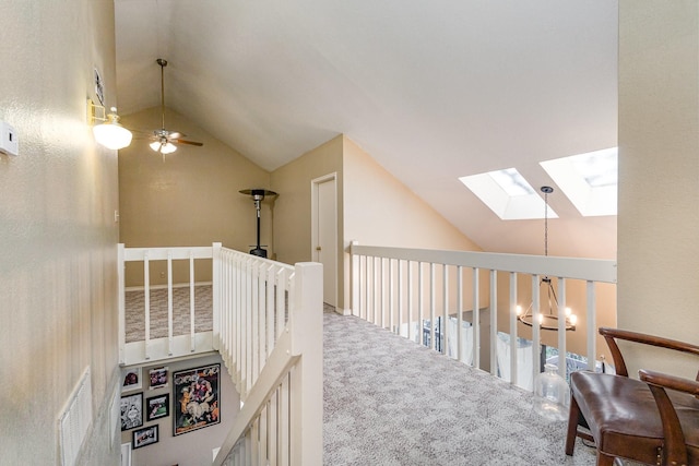 hall featuring vaulted ceiling with skylight and carpet floors