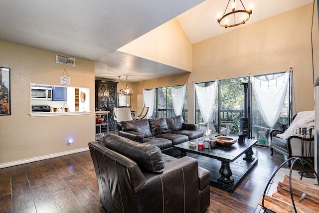 living room featuring dark wood-type flooring, vaulted ceiling, and a notable chandelier