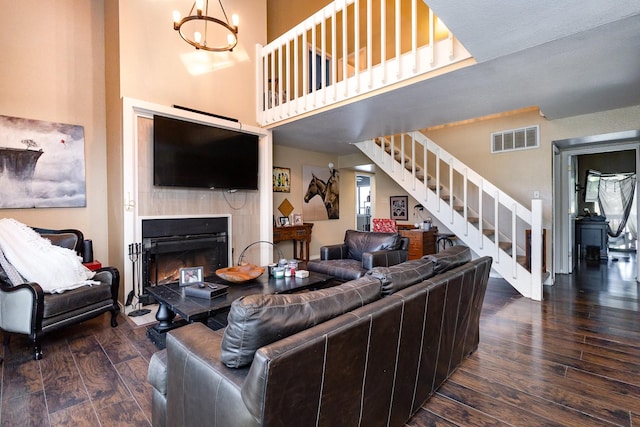 living room featuring a high ceiling, dark hardwood / wood-style flooring, and an inviting chandelier