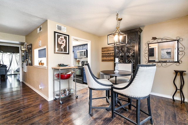 dining area featuring an inviting chandelier and dark wood-type flooring