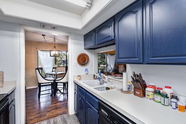 kitchen with dishwasher, an inviting chandelier, blue cabinets, sink, and dark hardwood / wood-style floors