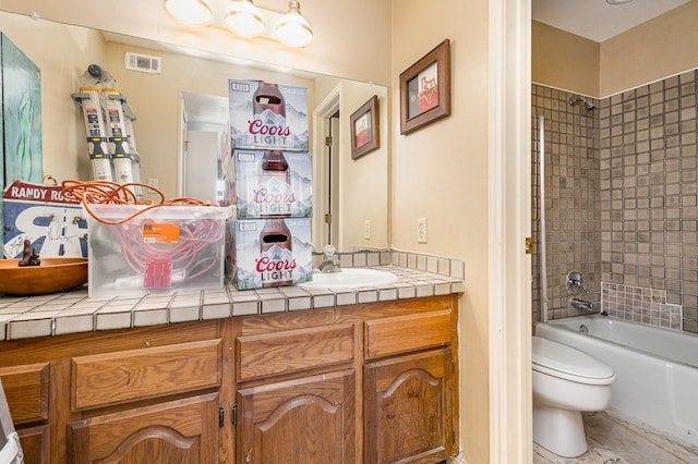 full bathroom with tiled shower / bath combo, toilet, and vanity