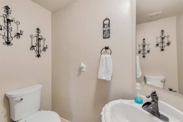 bathroom featuring sink, a textured ceiling, and toilet