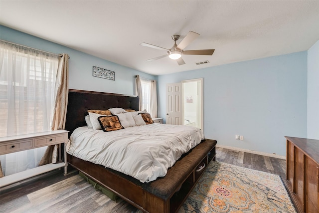 bedroom with multiple windows, dark wood-type flooring, and ceiling fan