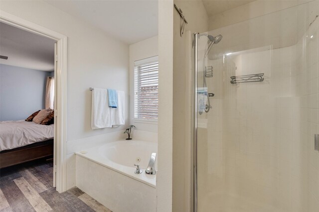 bathroom with hardwood / wood-style floors and independent shower and bath