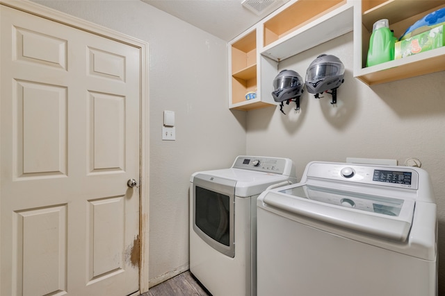 laundry area featuring hardwood / wood-style floors and washing machine and clothes dryer