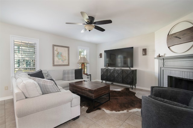 tiled living room with ceiling fan, a healthy amount of sunlight, and a fireplace