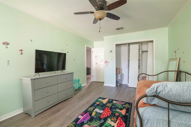 bedroom with ceiling fan, a closet, ornamental molding, and light wood-type flooring