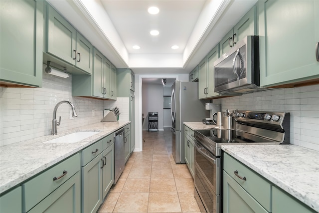 kitchen featuring green cabinets, light tile patterned floors, sink, and appliances with stainless steel finishes