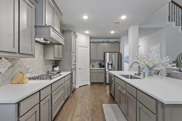 kitchen featuring dark wood-type flooring, stainless steel appliances, gray cabinets, and sink