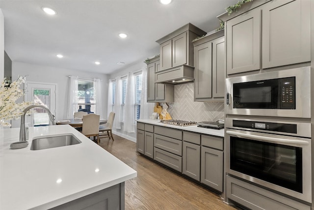 kitchen featuring premium range hood, appliances with stainless steel finishes, sink, and gray cabinetry