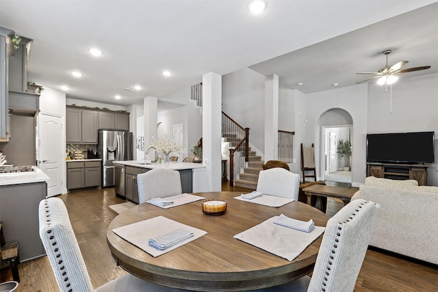 dining room featuring dark wood-type flooring, ceiling fan, and sink