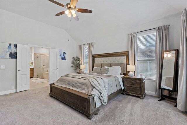 carpeted bedroom featuring ceiling fan, ensuite bath, and vaulted ceiling