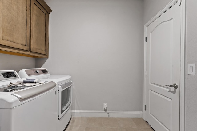 washroom with cabinets, washer and dryer, and light tile patterned floors