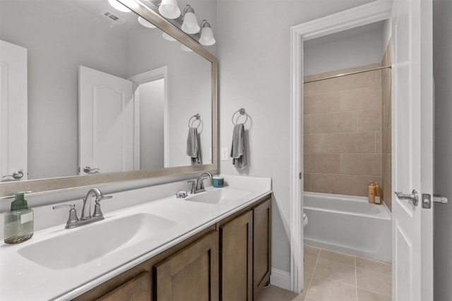 full bathroom featuring tile patterned flooring, vanity, tiled shower / bath combo, and toilet