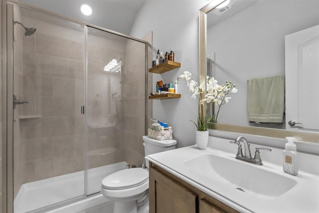 bathroom with vanity, toilet, and a shower with shower door