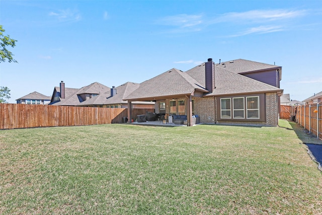 rear view of property with a yard and a patio area