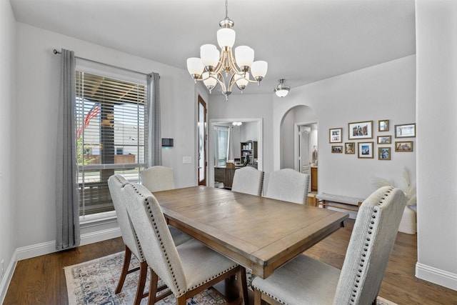 dining room with dark hardwood / wood-style flooring and a chandelier