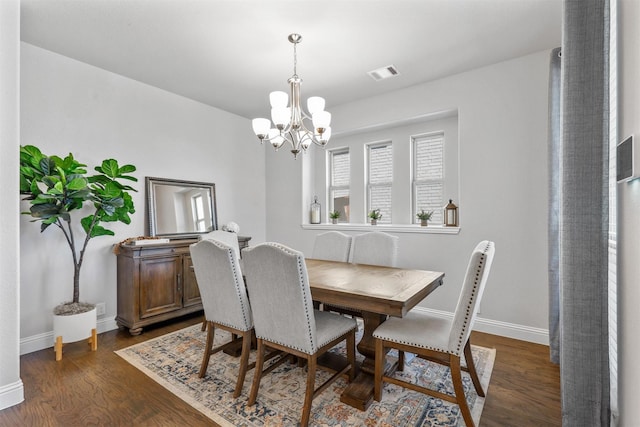 dining space with an inviting chandelier and dark hardwood / wood-style flooring