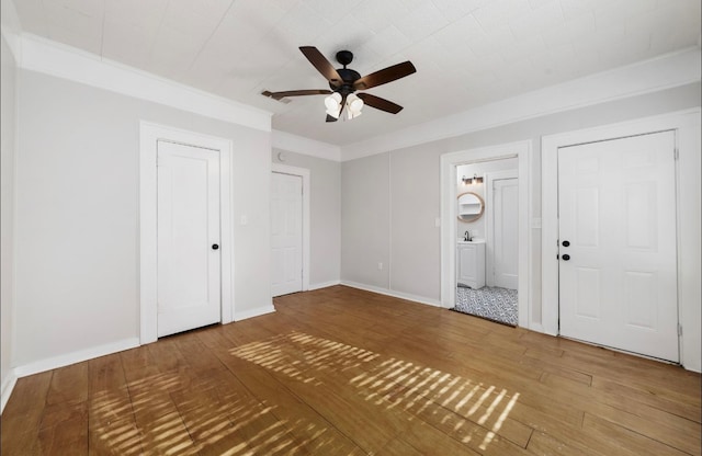 entrance foyer featuring hardwood / wood-style floors, ceiling fan, and ornamental molding