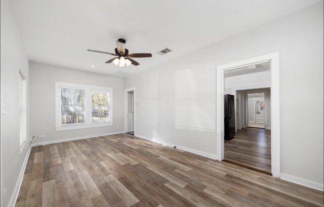 empty room with hardwood / wood-style floors and ceiling fan